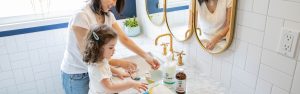 Daughter and mom washing hands in sink