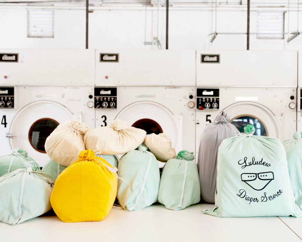 Diaper bags on ground in front of washing machines